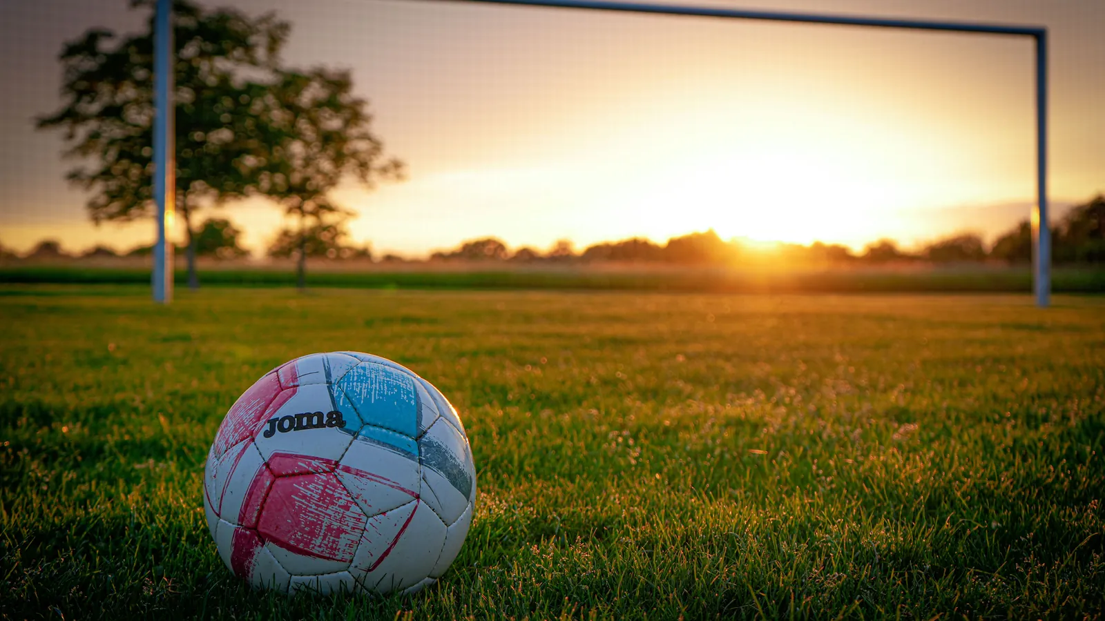 Fotball på gresset i solnedgang