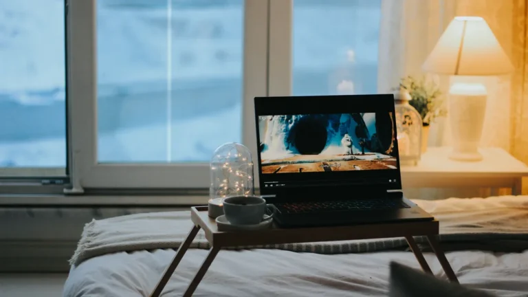 Laptop spiller film på sengebordet en vinterkveld
