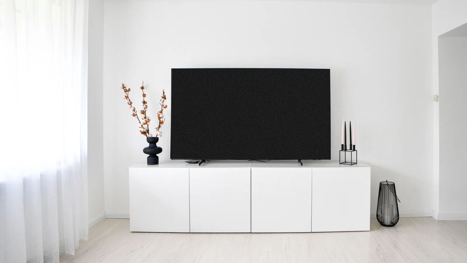 Lys nordisk stue med tv på benken
