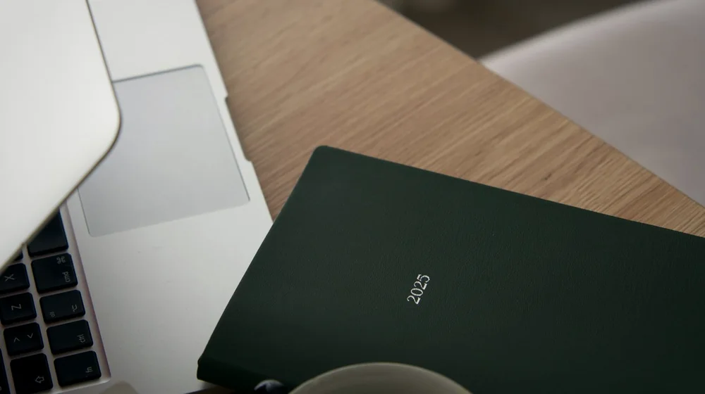 Notatbok, kaffe og laptop på et skrivebord når man vurderer erfaringer med nordic iptv