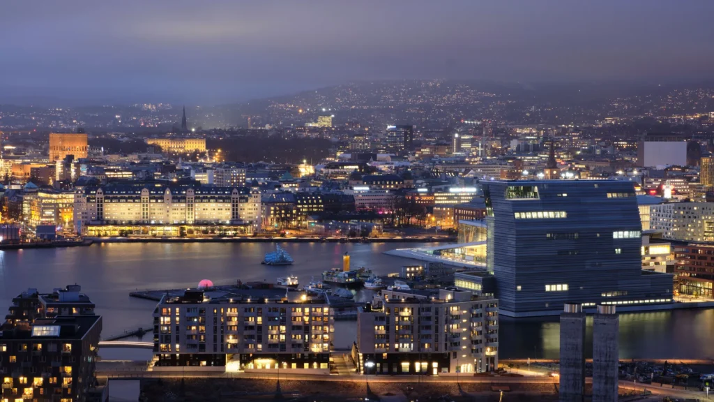 Oslo sett fra oven en kveld, med lys langs havnen
