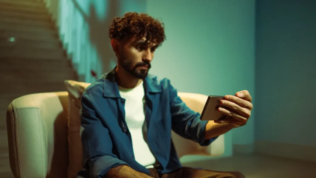 Mann vurderer et abonnement på mobilen i kveldslys